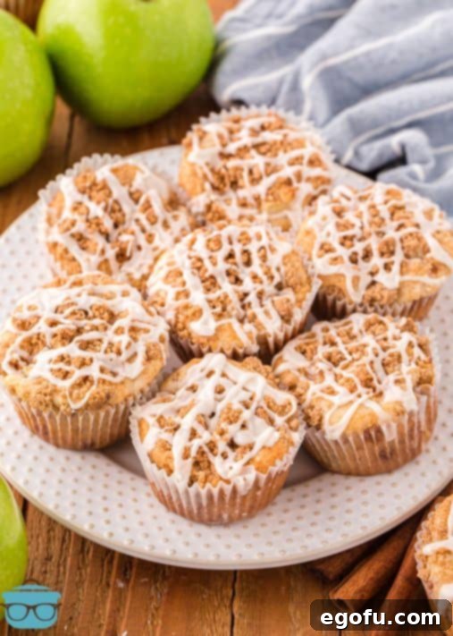 A beautiful plate of fresh-made Apple Streusel Muffins, perfectly drizzled with glaze, ready to be served.