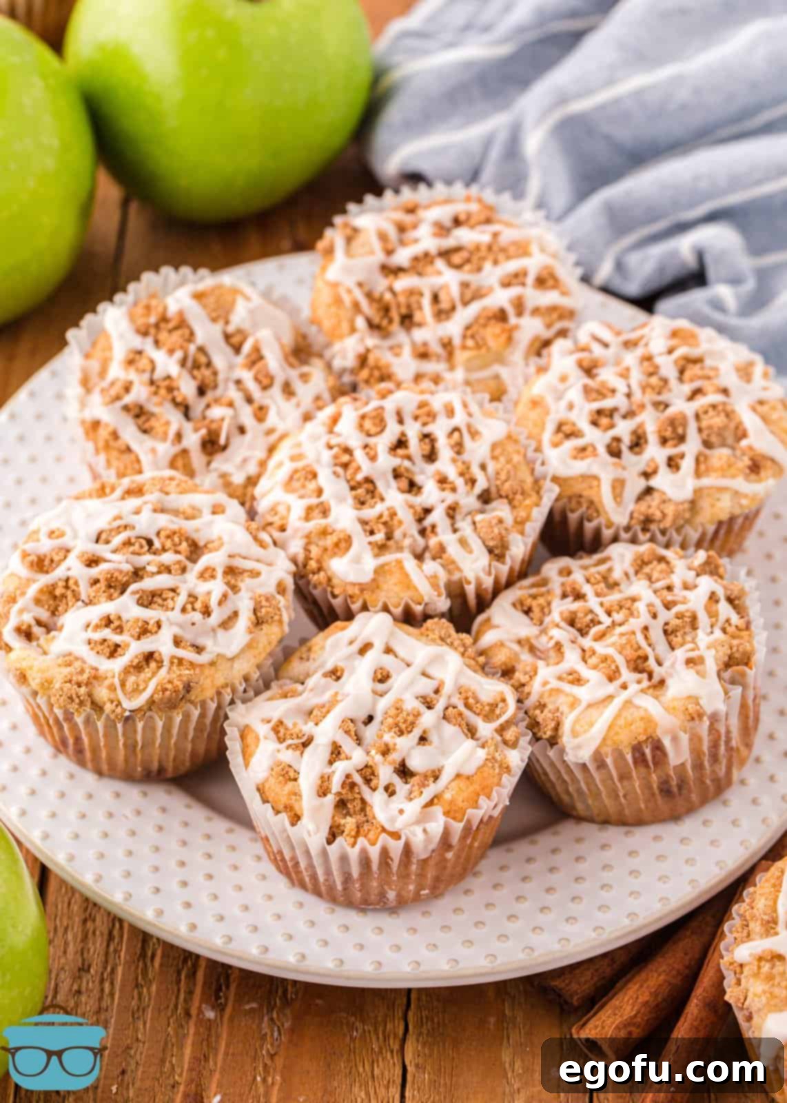 A white plate showcasing a delightful array of freshly made Apple Streusel Muffins, glistening with a sweet glaze.