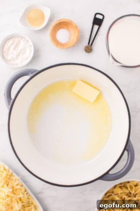 Panera's Signature Creamy Mac and Cheese 10 A large pot with a stick of butter melting on the stove.