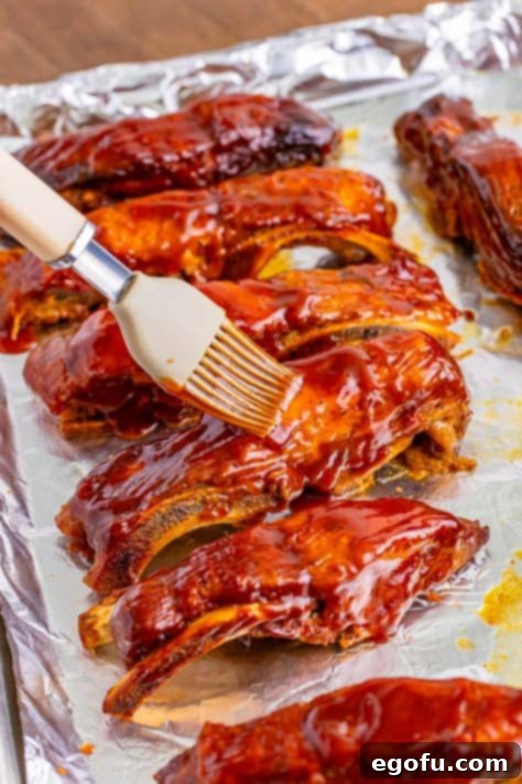 Tender Slow Cooker BBQ Country Style Ribs 16 A pastry brush brushing BBQ sauce on the ribs.