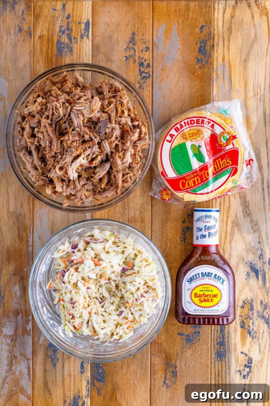 Down-Home Tacos 4 A collage of ingredients for Hillbilly Tacos: creamy coleslaw, tender shredded pork, a bottle of BBQ sauce, and warm corn tortillas.