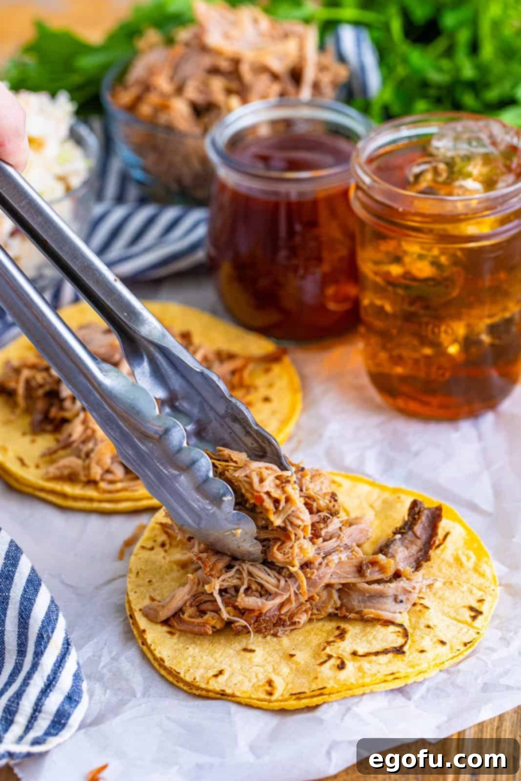 Down-Home Tacos 10 Shredded BBQ pork being placed on top of warm corn tortillas.