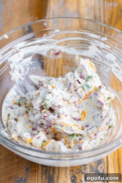 Savory Beef Cheese Delight 11 Cream cheese mixture with some dried beef, cheese, and green onions folded in in a mixing bowl.