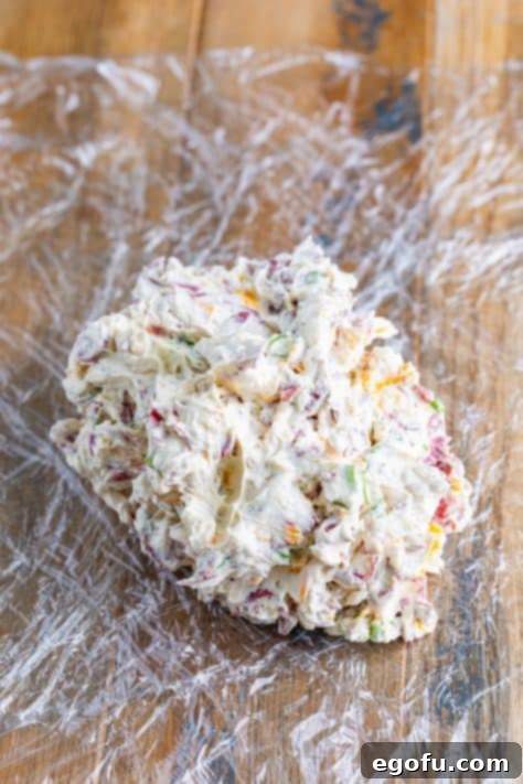 Savory Beef Cheese Delight 12 Cheeseball mixture on pieces of laid out plastic wrap.