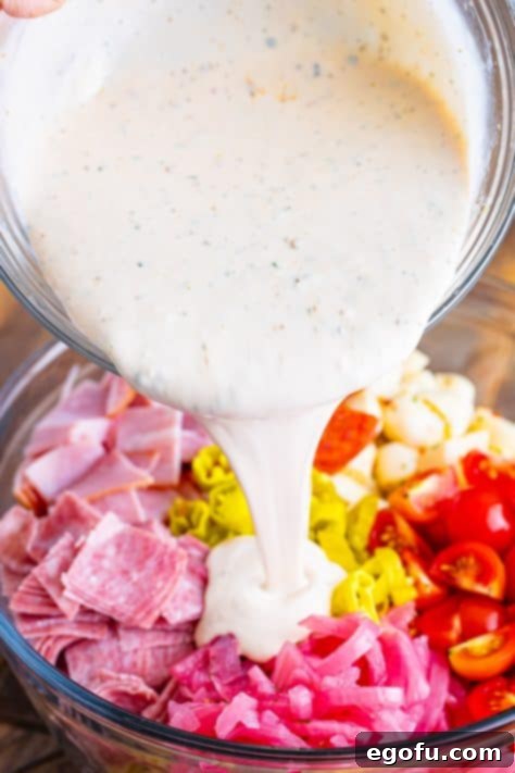 Dressing being poured on pasta salad.