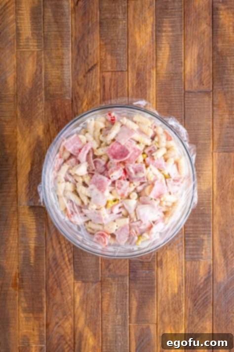 A covered mixing bowl of Grinder pasta salad minus the lettuce.