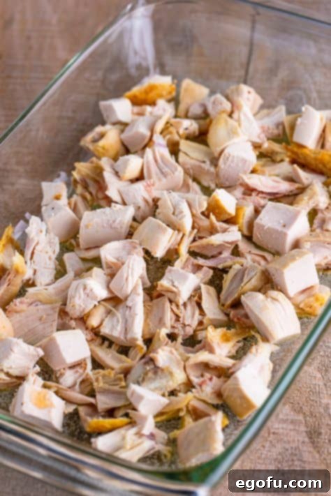 Rotisserie chicken and melted butter in a baking dish.