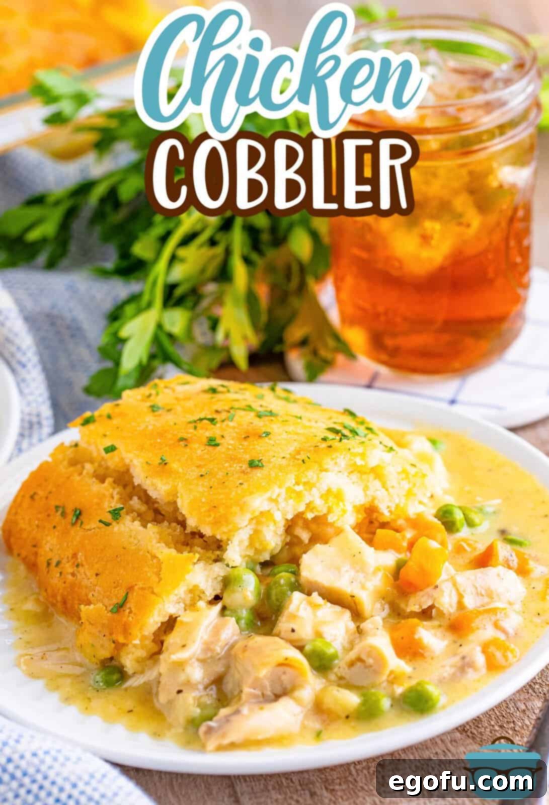 A large, golden brown Chicken Cobbler with a cheesy biscuit topping, served on a white plate.