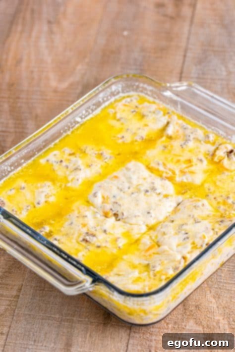 Dough being cut into squares in a baking dish.
