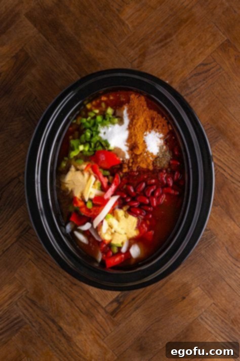 Copycat Wendy's Slow Cooker Chili 11 Slow cooker with ground beef, celery, peppers and onions, tomato sauce, stewed tomatoes, kidney beans, chili beans, diced tomatoes with green chilies, beef broth, chili seasoning, sugar, vinegar, garlic powder, onion powder, pepper, and salt.