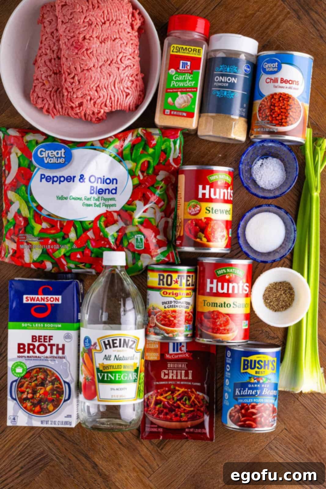 Copycat Wendy's Slow Cooker Chili 4 Ground beef, celery, frozen peppers and onions, tomato sauce, stewed tomatoes, red kidney beans, chili beans, diced tomatoes, beef broth, chili seasoning, sugar, white vinegar, garlic powder, onion powder, black pepper, and kosher salt.