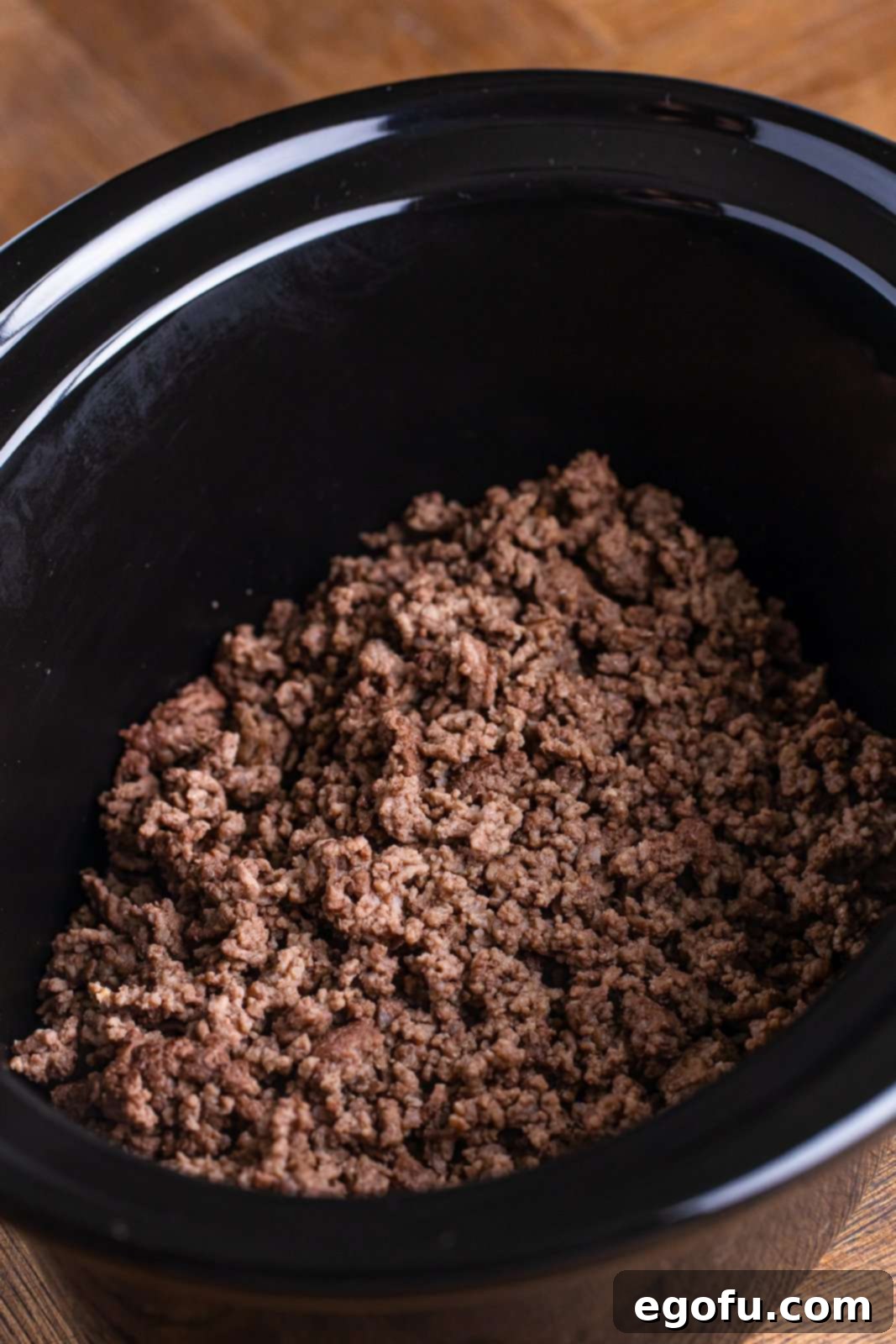 Copycat Wendy's Slow Cooker Chili 5 A slow cooker insert filled with ground beef.