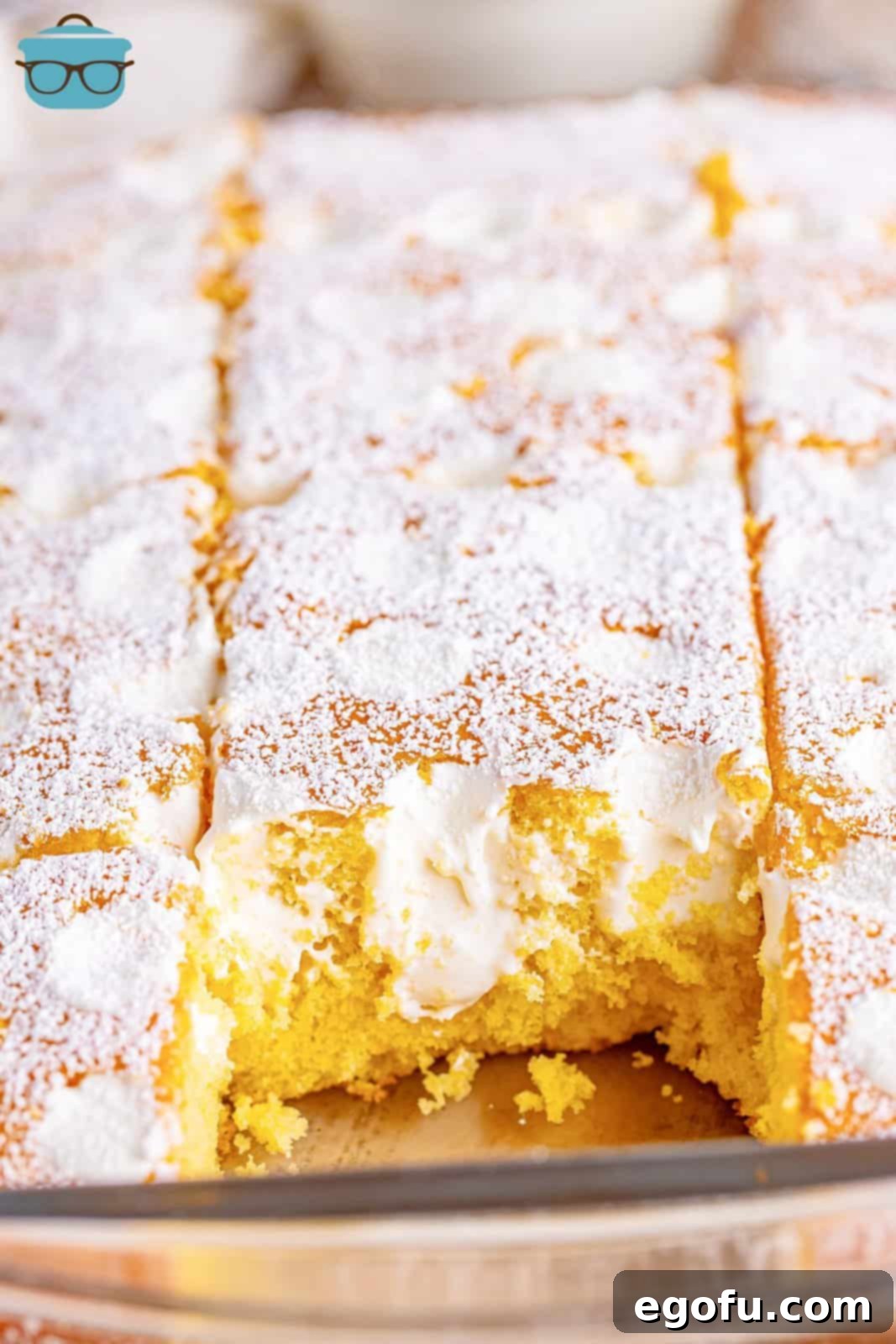 A cut up Twinkie Poke Cake with a piece removed, revealing the creamy marshmallow filling within the poked holes.