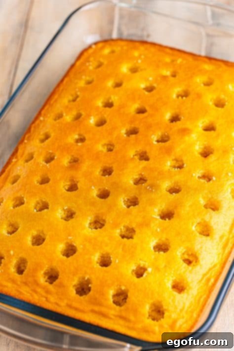 Holes poked into a yellow cake.