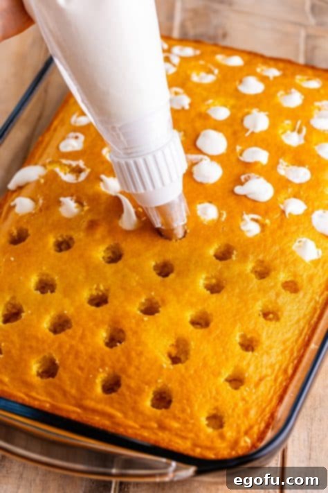Frosting being put in the holes of a poke cake.