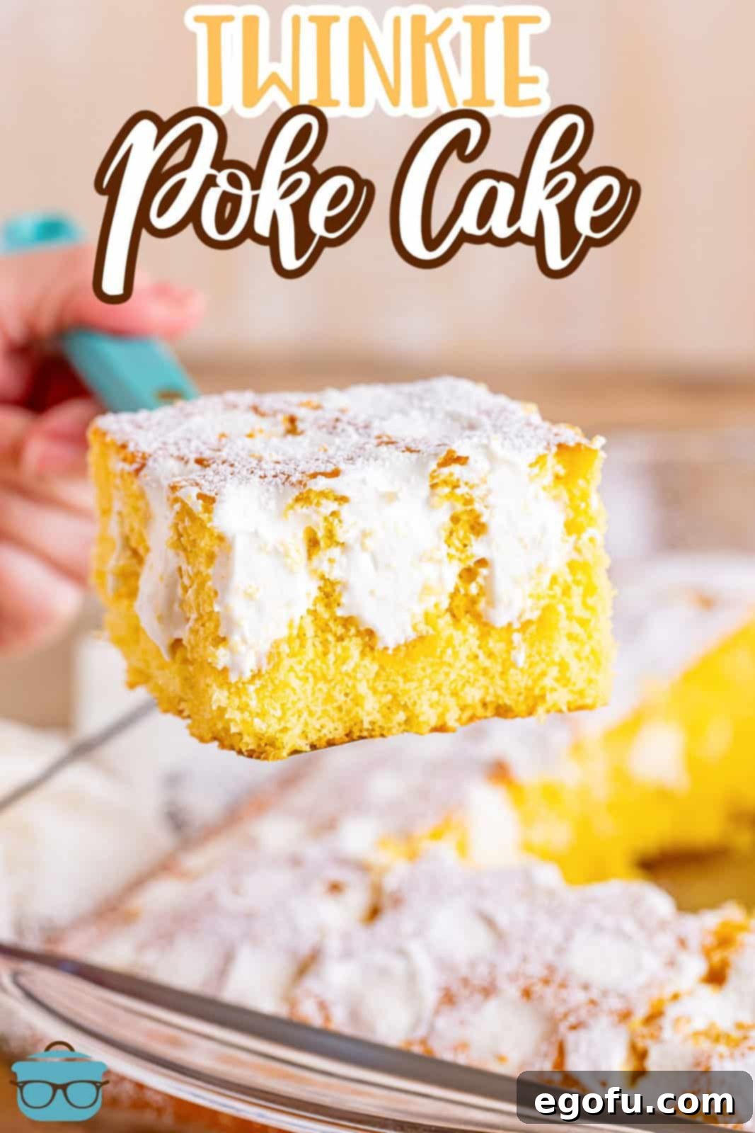 A tantalizing slice of Twinkie Poke Cake held above the baking dish, showcasing its golden cake and creamy white filling.