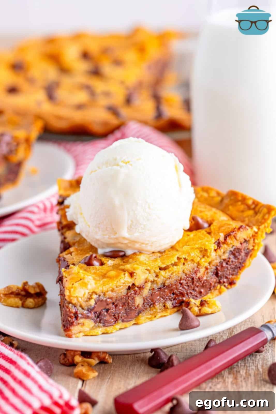 A slice of Tollhouse cookie pie with a scoop of vanilla ice cream.