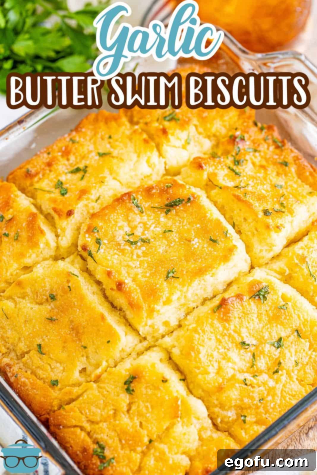 Garlic Butter Bath Biscuits 3 A glistening glass dish of freshly baked Garlic Butter Swim Biscuits, showing their golden tops.