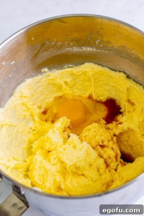Eggs in a butter and sugar mixture in a mixing bowl.