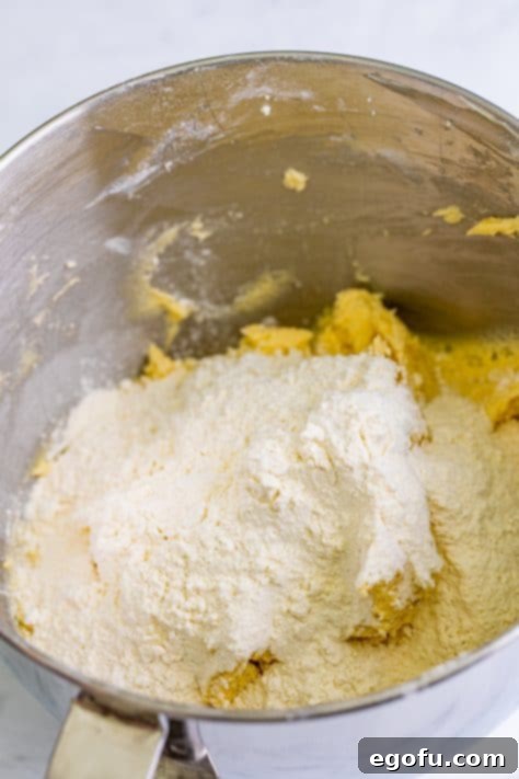 Dry ingredients being added to the wet ingredients in a mixing bowl.