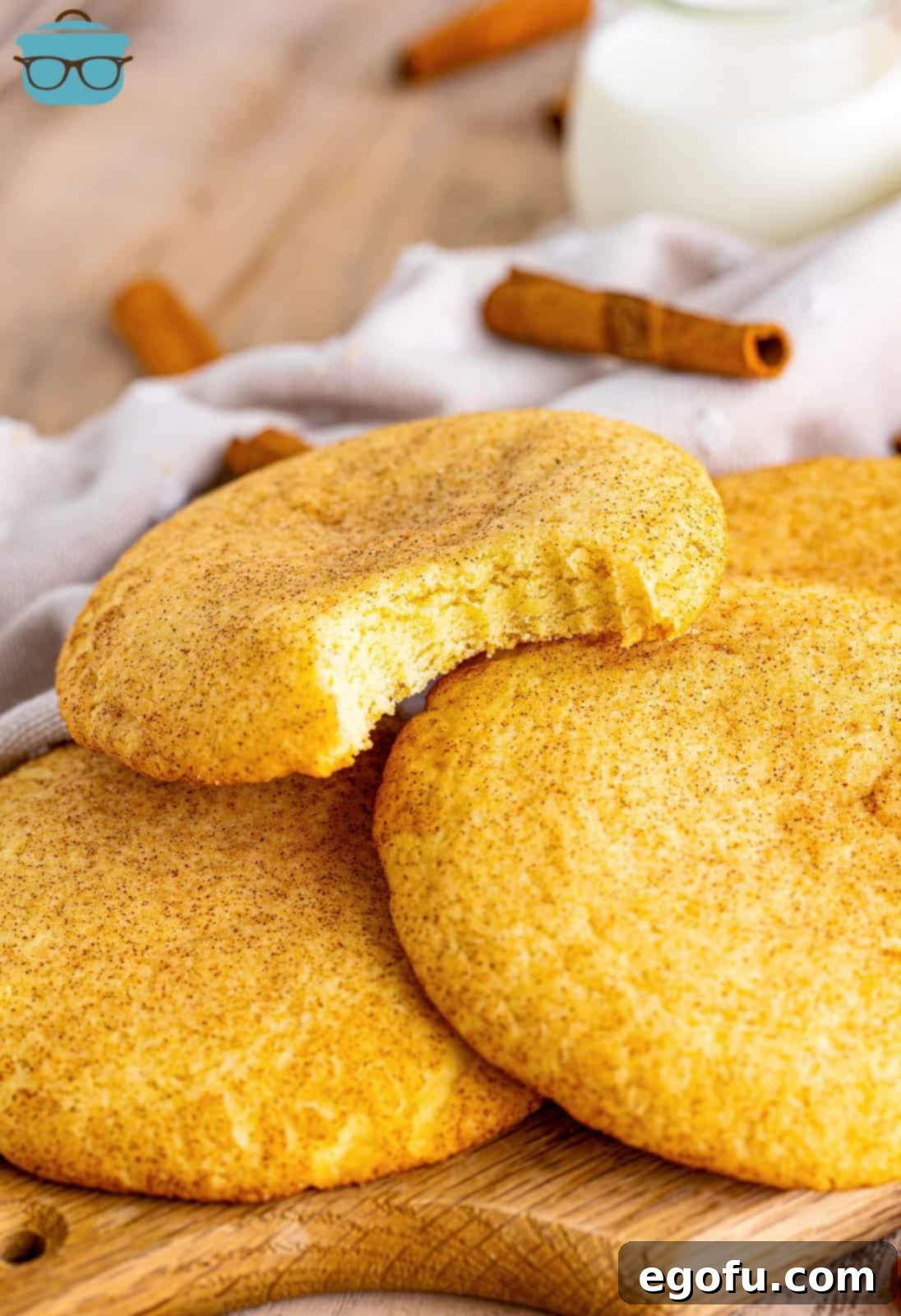 A generous pile of freshly baked homemade Crumbl Snickerdoodles, showcasing their inviting golden color and cinnamon-sugar sparkle.