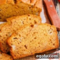A few slices of Banana Pumpkin Bread artfully arranged on a cutting board, ready to be enjoyed.