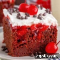 A slice of Black Forest Poke Cake on a small plate, ready to be enjoyed.