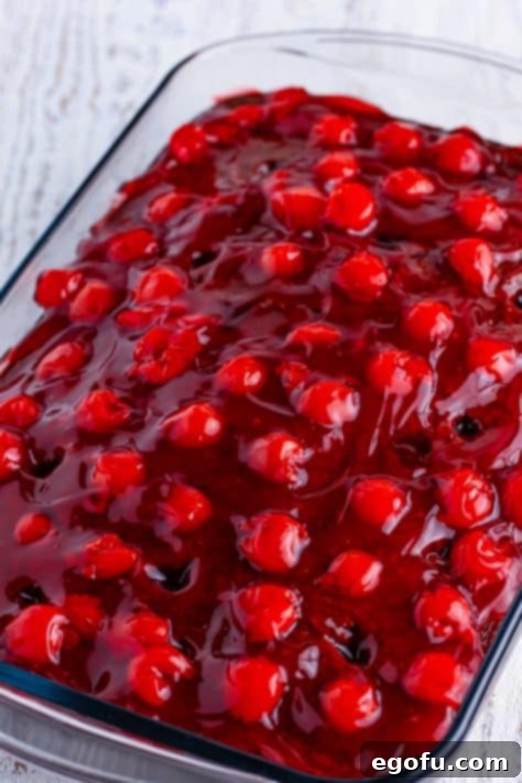A cherry pie filling spread over a chocolate cake.
