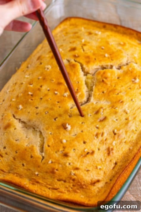 A chopstick poking holes in a cake.