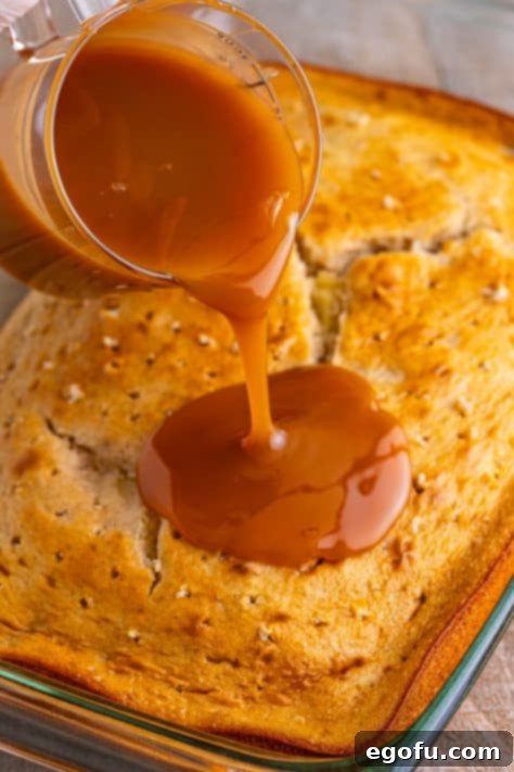 Caramel sauce being poured on a cake.