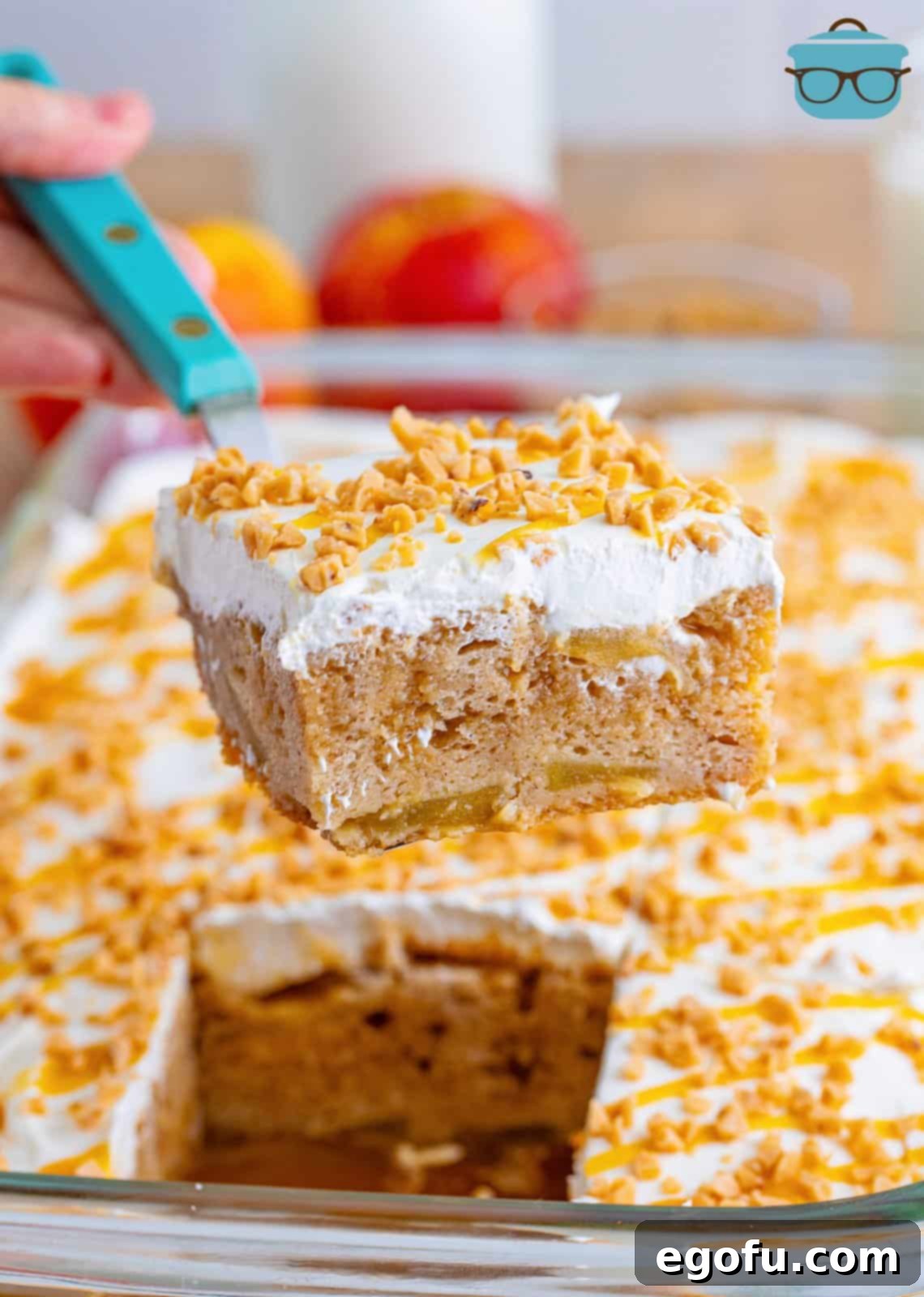 Serving utensil holding a slice of apple pie poke cake.
