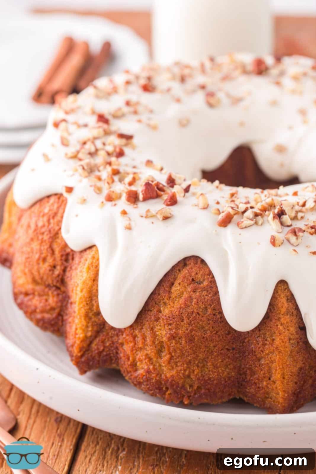 a freshly glazed pumpkin Bundt cake on a serving plate.