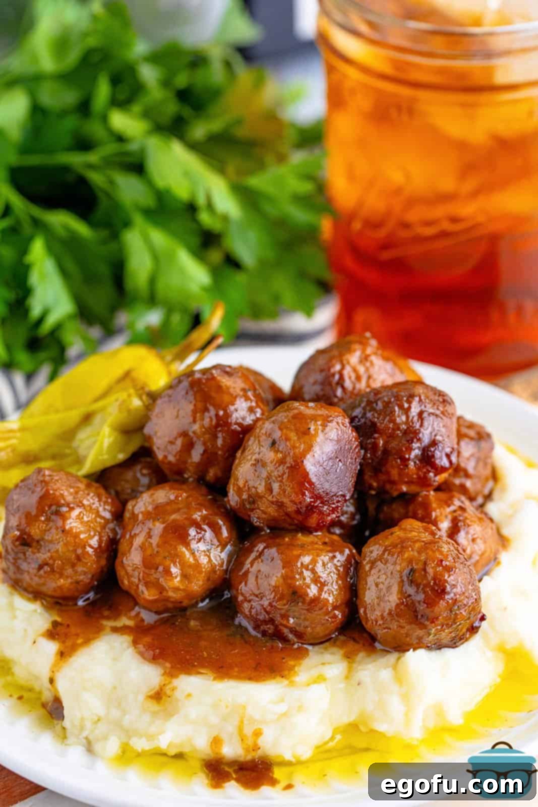 A plate of mashed potatoes and Crock Pot Mississippi Meatballs.