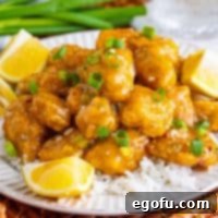 Close up looking at a plate with Asian Lemon Chicken on a bed of white rice.