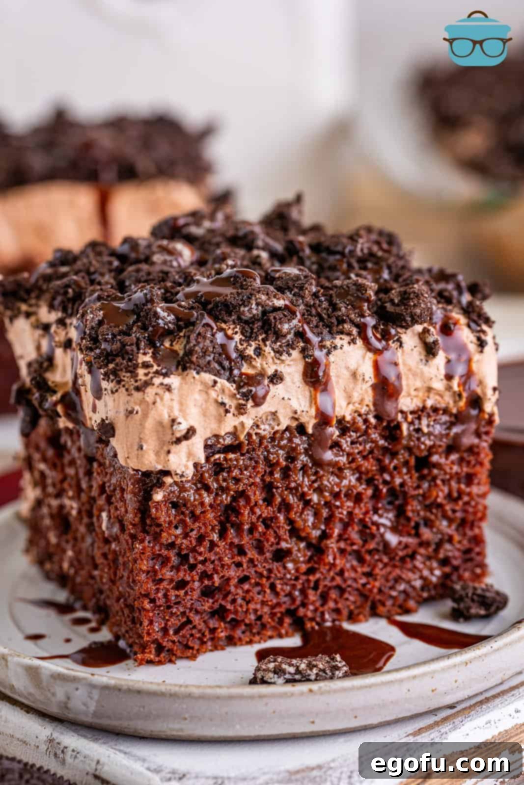 Heavenly Oreo Dream Cake 2 A slice of Oreo Better Than Sex cake sitting on a white plate, showcasing its layers and crunchy topping.