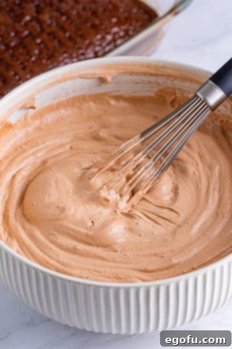 Heavenly Oreo Dream Cake 16 Chocolate frosting being prepared in a bowl.