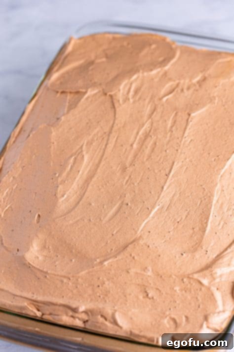 Heavenly Oreo Dream Cake 17 Chocolate frosting spread generously over a chocolate cake.