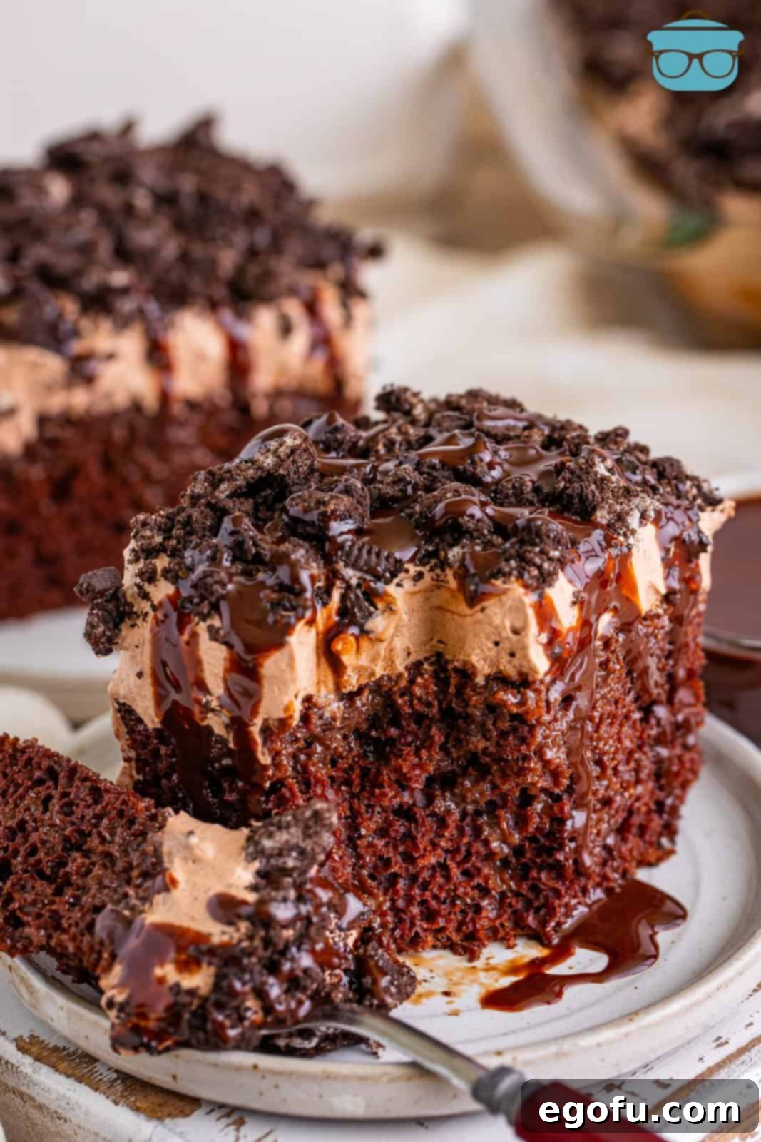 Heavenly Oreo Dream Cake 9 A plate featuring a slice of Oreo Better Than Sex Cake with a bite missing, highlighting its deliciousness and inviting texture.