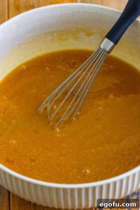 Gooey Pecan Pull-Apart Bake 11 A small mixing bowl with corn syrup, brown sugar, melted butter, eggs, and vanilla.