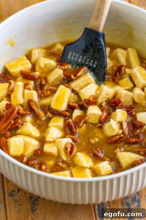 Gooey Pecan Pull-Apart Bake 13 Chopped pecans and biscuits in the sauce in a bowl.