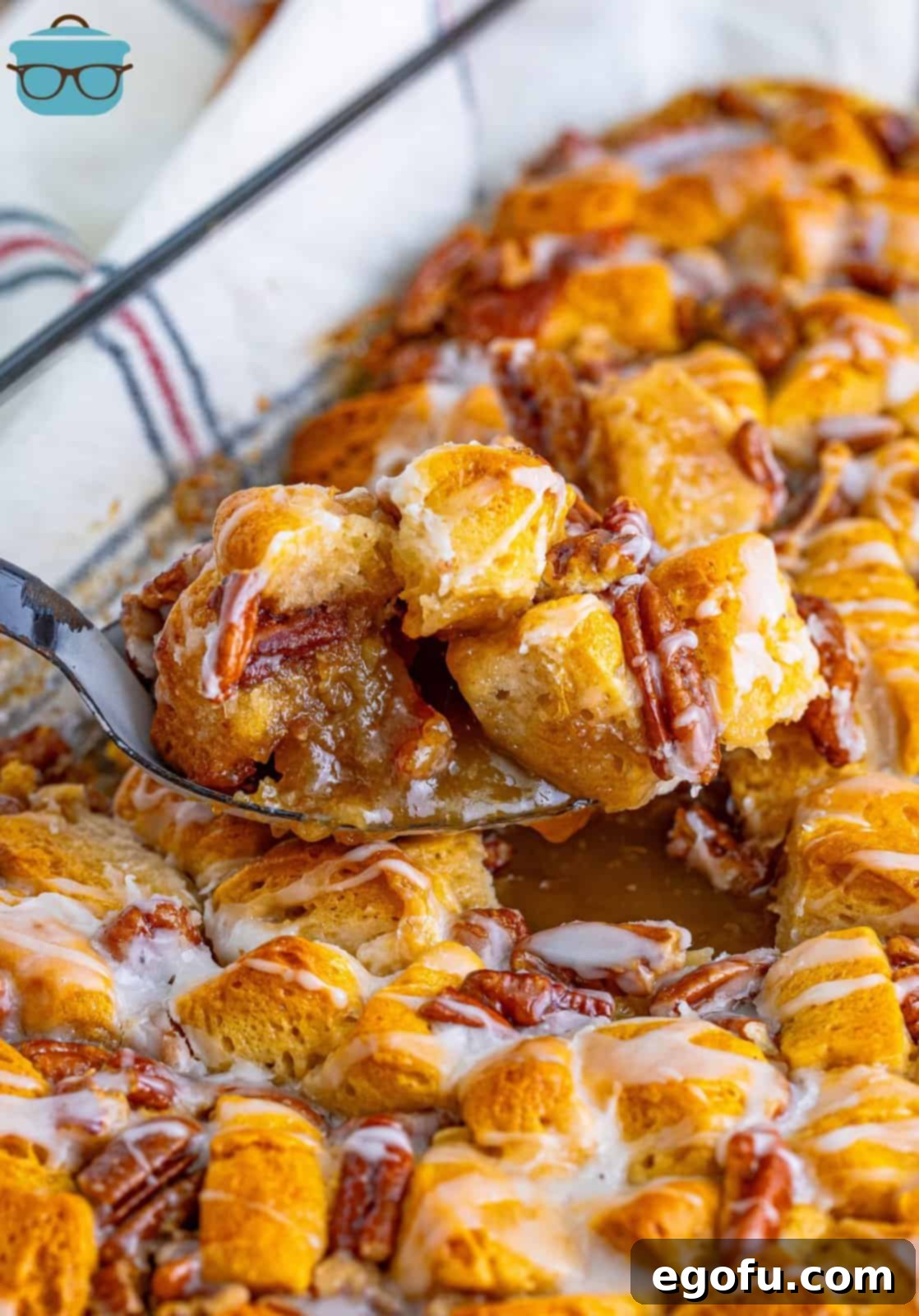 Gooey Pecan Pull-Apart Bake 9 A serving of Pecan Pie Bubble Up being lifted from the baking dish, showcasing its gooey layers and golden-brown biscuits.