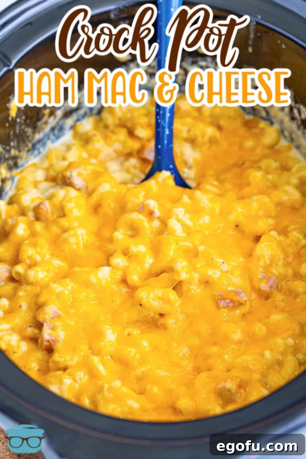 A large crockpot insert filled with creamy ham mac and cheese, ready for serving.
