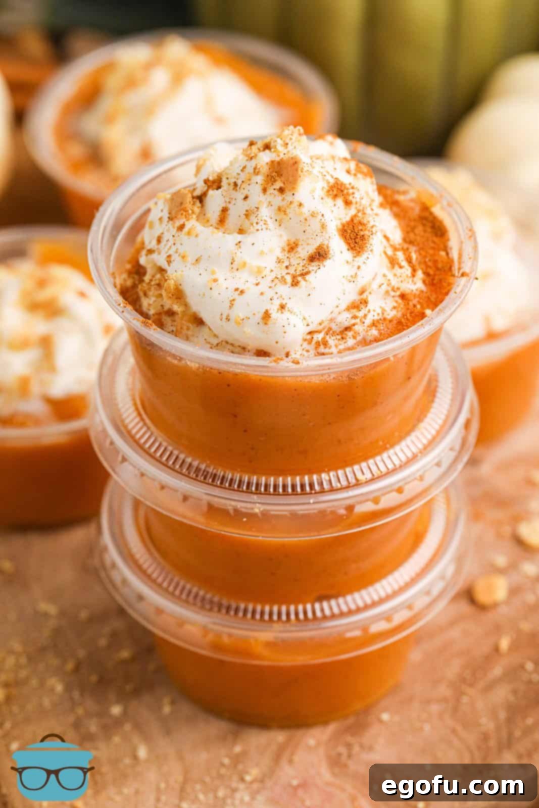 A stack of delightful Pumpkin Pie Pudding Shots, with the top one showcasing its creamy texture and inviting fall colors.