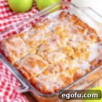 Close up looking at a baking dish of Apple Pie Butter Dip Biscuits with glaze on top.