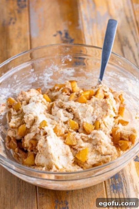 Apple mixture and biscuit dough mixture together in a bowl.