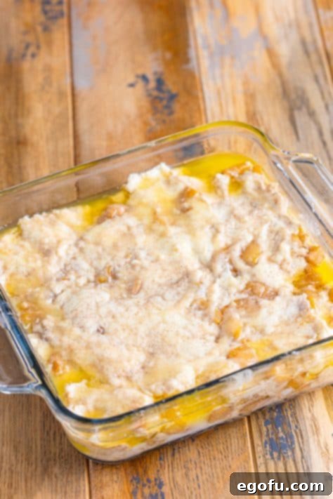 Apple biscuit dough and butter in a baking dish.
