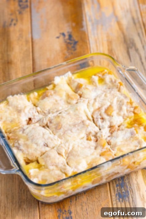 Biscuit dough with slash marks in it in a baking dish.