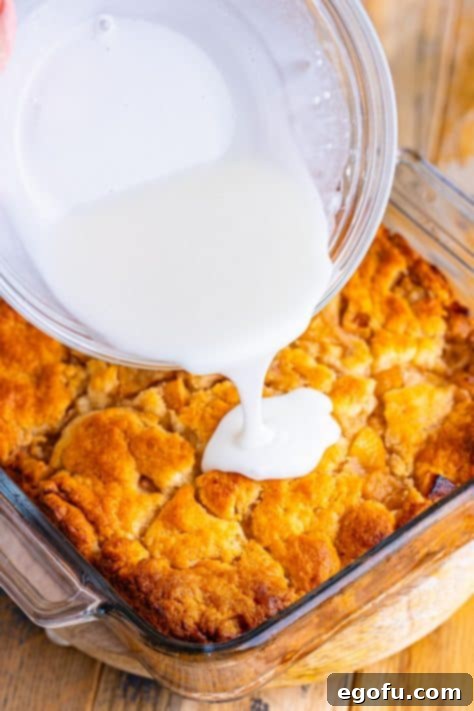Powdered sugar glaze being poured on butter dip biscuits.