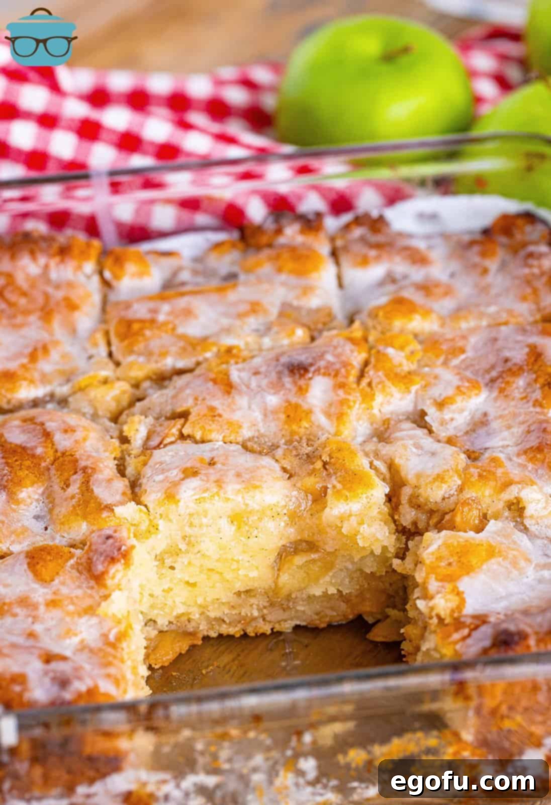 A baking dish of apple Pie Butter Swim Biscuits with one removed from the dish.