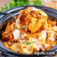 One-Pot Pizza Magic 16 A serving utensil lifting some Crock Pot Pizza Casserole out of the Slow Cooker.